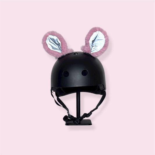 Black helmet with pink bunny ears on a light pink background